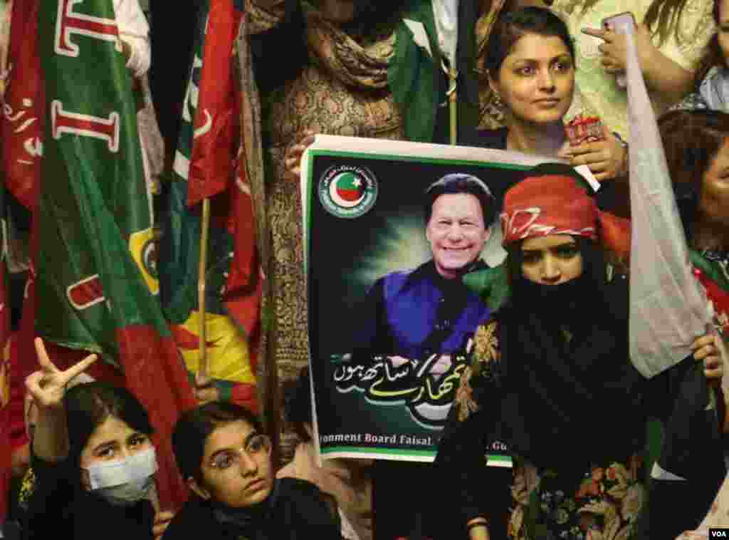 سابق وزیرِ اعظم عمران خان کی حکومت کے خاتمے کے خلاف احتجاج میں شریک مظاہرین نے ہاتھوں میں پاکستان تحریک انصاف کے جھنڈے اور عمران خان کی تصاویر اٹھا رکھی ہیں۔