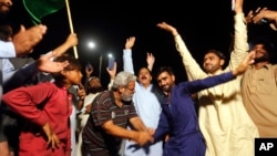 Para pendukung partai oposisi merayakan kesuksesan mosi tidak percaya terhadap Perdana Menteri Imran Khan di Karachi, Pakistan, 10 April 2022. (Foto: Fareed Khan/ AP Photo)