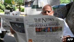 A man reads a newspaper in Islamabad on April 8, 2022, after Pakistan's Supreme Court ruled that the National Assembly must reconvene to hold a no-confidence vote on Prime Minister Imran Khan.