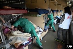 FILE - Members of an MSF team care for patients on a medical evacuation train on its way to the western Ukrainian city of Lviv, April 10, 2022.