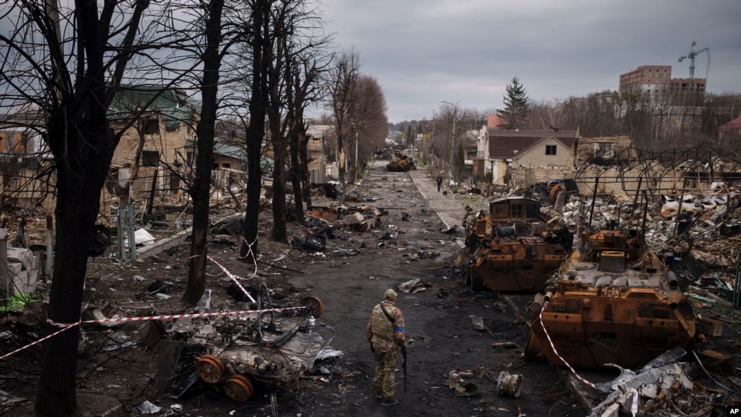 Seorang tentara Ukraina berjalan di tengah tank-tank Rusia yang hancur di Bucha, di pinggiran Kyiv, Ukraina, 6 April 2022. (Foto: Felipe Dana/AP)
