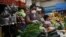 Una mujer indígena usa una mascarilla y guantes como medida preventiva contra el nuevo coronavirus, COVID-19, mientras vende verduras en el Mercado Central de la Ciudad de Guatemala, el 16 de marzo de 2020.