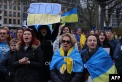 People with Ukrainian flags protest from the sidelines against a pro-Russian march in Frankfurt am Main, western Germany, April 10, 2022, amid Russia's war against Ukraine.