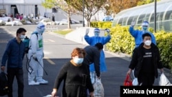 Kloter pertama pasien yang telah sembuh dari COVID-19 pergi meninggalkan rumah sakit darurat di Shanghai, China, pada 9 April 2022. (Foto: Xinhua via AP/Jin Liwang)