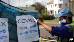 FILE - An airport worker handles the cargo of COVID-19 vaccines, donated through the UN-backed COVAX program, on arrival in Antananarivo, Madagascar, May 8, 2021.