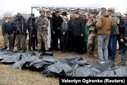 Presiden Komisi Uni Eropa Ursula von der Leyen (tengah) melihat mayat-mayat warga sipil yang terbunuh di kota Bucha, di pinggiran Kyiv, Ukraina (8/4). (Foto: AP)