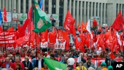 Communist party supporters wave red flags during a protest in the center of Moscow, Russia, Saturday, Aug. 17, 2019. People rallied Saturday against the exclusion of some city council candidates from Moscow's upcoming election.