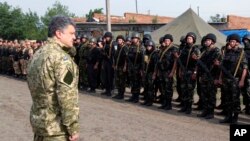 FILE - In this photo taken June 20, 2014, in Izyum, near Slovyansk, eastern Ukraine, Ukrainian President Petro Poroshenko visits troops. 