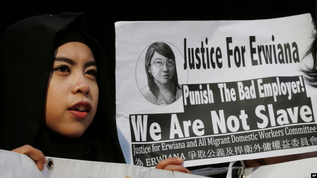 A supporter of Indonesian maid Erwiana Sulistyaningsih, holds a placard as Sulistyaningsih arrives at a court in Hong Kong, Feb. 10, 2015.