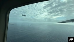 资料照片：一架中国军用直升机在南中国海有争议的斯卡伯勒浅滩(Scarborough Shoal，中国称黄岩岛)上空飞近菲律宾渔业和水产局(BFAR)的飞机。(2025年2月18日)