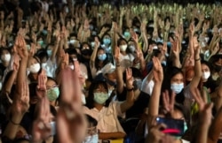 Pro-democracy students raise a three-finger salute, a resistance symbol borrowed by Thailand's anti-coup movement from the movie "The Hunger Games," during a protest at Thammasat University near Bangkok, Thailand, Aug, 10, 2020.