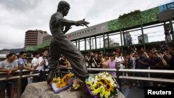 Para penggemar legenda kung fu Bruce Lee menghiasi patungnya di pelabuhan Victoria, Hong Kong dengan karangan bunga untuk menghormati 40 tahun kematiannya (20/7).