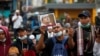 Seorang demonstran mengacungkan gambar Rizieq Shihab yang baru saja divonis karena melanggar pembatasan terkait COVID-19, Kamis, 24 Juni 2021. (Foto: Willy Kurniawan/Reuters)