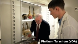 Curator, Dr. Paul Michael Taylor (Left) and Ethnomusicologist, Tyler A Kramlich (Right)opening the cabinet with the Thai Khon mask collection