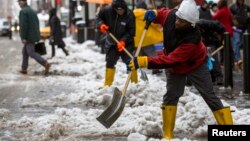 Decenas de trabajadores limpian las calles en Nueva York golpeada este invierno por intensas nevadas.