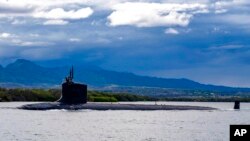 FILE - In this photo provided by U.S. Navy, a submarine departs Joint Base Pearl Harbor-Hickam, Sept. 1, 2021. 