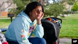 Ivanni Herrera looks on during an interview in an Aurora, Colorado, park on May 18, 2024. A migrant from Venezuela, Herrera was eight months pregnant when she and her 4-year-old son were turned out onto the streets on a chilly November night.