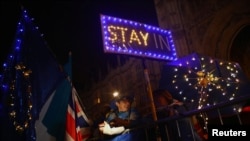 Anti-Brexit demonstrators stand outside the Houses of Parliament in London, Sept. 9, 2019.