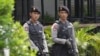 FILE - Armed police stand outside the Starbucks cafe where an attack occurred on Thursday, in Jakarta, Indonesia, Jan. 15, 2016. 