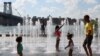 Grupo de personas se refrescan en fuentes públicas durante una ola de calor en Brooklyn, Nueva York, el 8 de agosto de 2022.