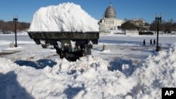 A loader piles a full bucket of snow in front of the U.S. Capitol Building in Washington, D.C., Jan. 24, 2016.