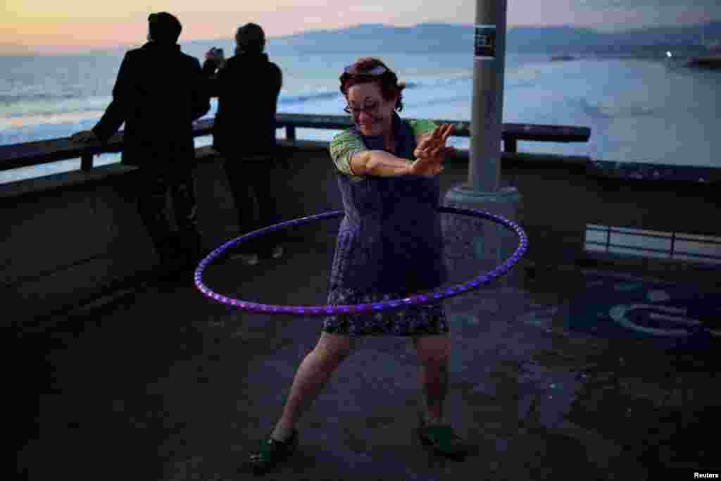 A woman hula hoops along the Venice Pier in Los Angeles, California, Nov. 18, 2024. REUTERS/Daniel Cole TPX