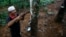 FILE - Roslai Hasan makes incisions on a rubber tree's bark to tap rubber at a plantation at Hulu Rening in the district of Batangkali, outside Kuala Lumpur, May 26, 2014.