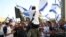 FILE - Israelis nationalists wave national flags during a Jerusalem Day march, in Jerusalem, May 10, 2021. 