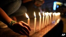 FILE - Activists light candles as they condemn the killing of Filipino journalist Percival Mabasa during a rally in Quezon, Philippines, Oct. 4, 2022.