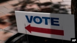 A Vote sign is placed outside of an early voting location, Monday, Oct. 31, 2022, in Miami. U.S. midterm elections are Nov. 8. 