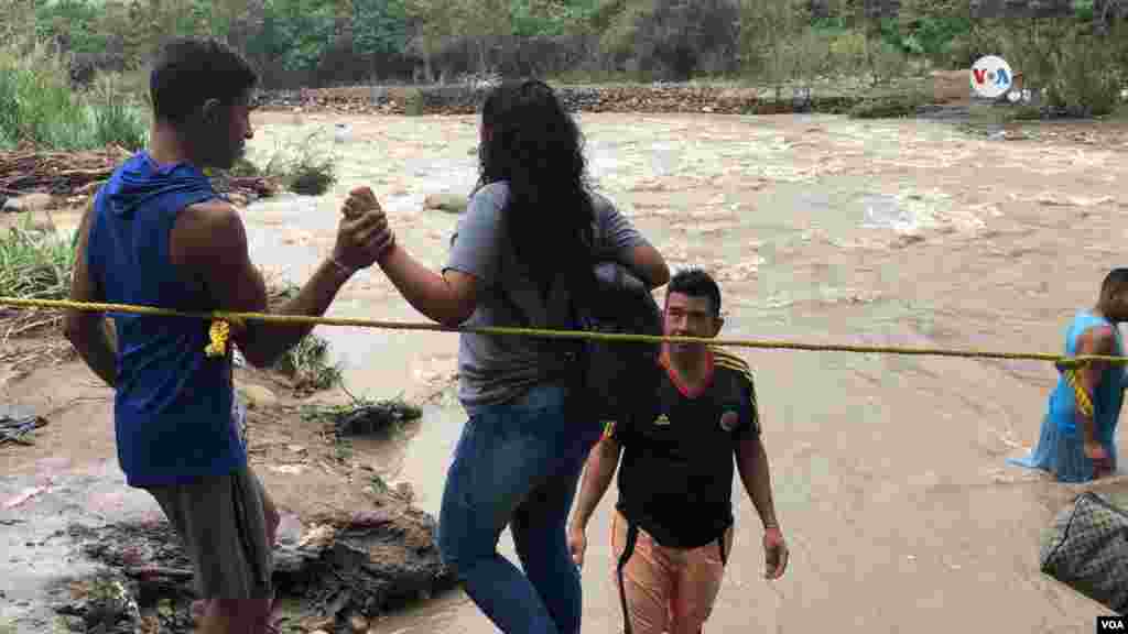 Venezolanos intentan cruzar el río Táchira, sin importar los peligros.