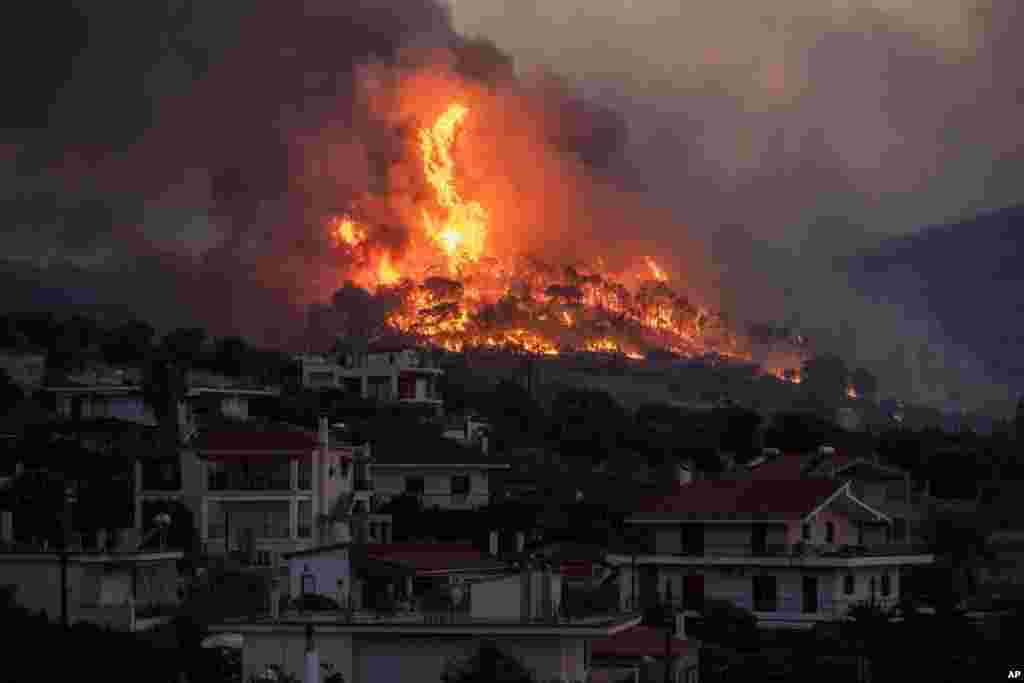 A fire burns near the village of Galataki as authorities evacuate residents near Corinth, Greece, July 22, 2020.