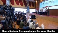 Para jurnalis sedang meliput konferensi pers. (Foto: Badan Nasional Penanggulangan Bencana/BNPB)