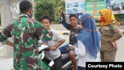 Petugas menasehati pengendara sepeda motor yang tidak menggunakan masker saat pelaksanaan PSBB di Buol, Sulteng, 14 Mei 2020. (Foto: Diskominfo Buol)