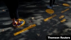 People line up following social distance rules as a preventive measure against the spread of COVID-19 at a street market in Buenos Aires, Argentina, May 20, 2020. 