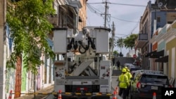 Trabajadores de electricidad realizan reparaciones en la comunidad de Puerta de Tierra tras el paso de la tormenta tropical Ernesto en San Juan, Puerto Rico, el jueves 15 de agosto de 2024. 