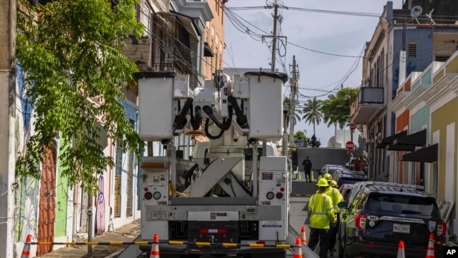 Trabajadores de electricidad realizan reparaciones en la comunidad de Puerta de Tierra tras el paso de la tormenta tropical Ernesto en San Juan, Puerto Rico, el jueves 15 de agosto de 2024. 
