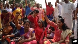 FILE - Protestors block traffic and shout slogans reacting to reports of two women of menstruating age entering the Sabarimala temple, in Thiruvananthapuram, Kerala, India, Jan. 2, 2019.