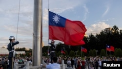 Honor guards lower the Taiwanese flag during a ceremony at Chiang Kai-shek Memorial Hall in Taipei, Taiwan, Oct. 12, 2024.