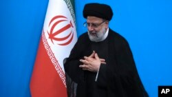 FILE - Iranian President Ebrahim Raisi places his hands on his heart as a gesture of respect as he leaves after a press conference in Tehran, Iran, Aug. 29, 2023.