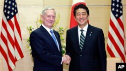 U.S. Defense Secretary Jim Mattis, left, and Japanese Prime Minister Shinzo Abe, right, shake hands at the prime minister's office in Tokyo, Feb. 3, 2017. 