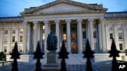 FILE - The U.S. Treasury Department building is seen at dusk, June 6, 2019, in Washington. 