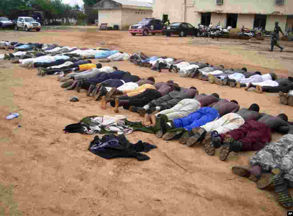 Members of an local Islamic group lie on the ground at a police station after their arrest in the northeastern city of Bauchi, July 25, 2009. Gun battles raged for days last week as the security forces fought to put down uprising by members of Boko Haram,