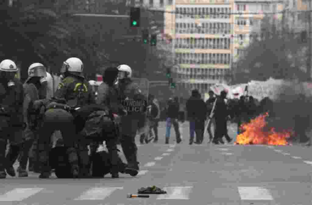 Riot police detain a protester during clashes in central Athens on Wednesday, Feb. 23, 2011. Scores of youths hurled rocks and petrol bombs at riot police after clashes broke out Wednesday during a mass rally taking place as part of a general strike. (AP