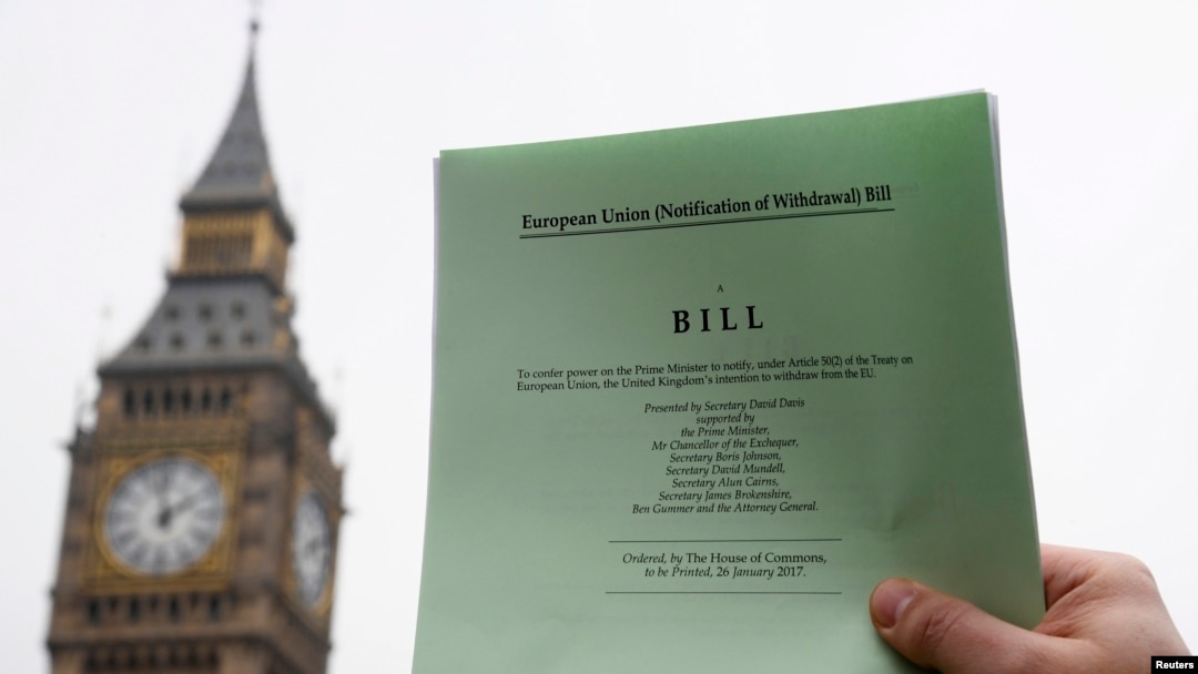 Seorang jurnalis di London berpose dengan salinan RUU Brexit yang sedang diperdebatkan parlemen Inggris. (Reuters/Troby Melville)