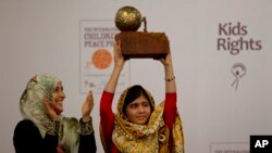 Pelajar Pakistan Malala Yousafzai (kanan) menerima penghargaan "the International Children's Peace Prize 2013" yang diserahkan oleh penerima Nobel Perdamaian tahun 2011, Tawakkol Karman dari Yaman (kiri), di Den Haag, Belanda (6/9).