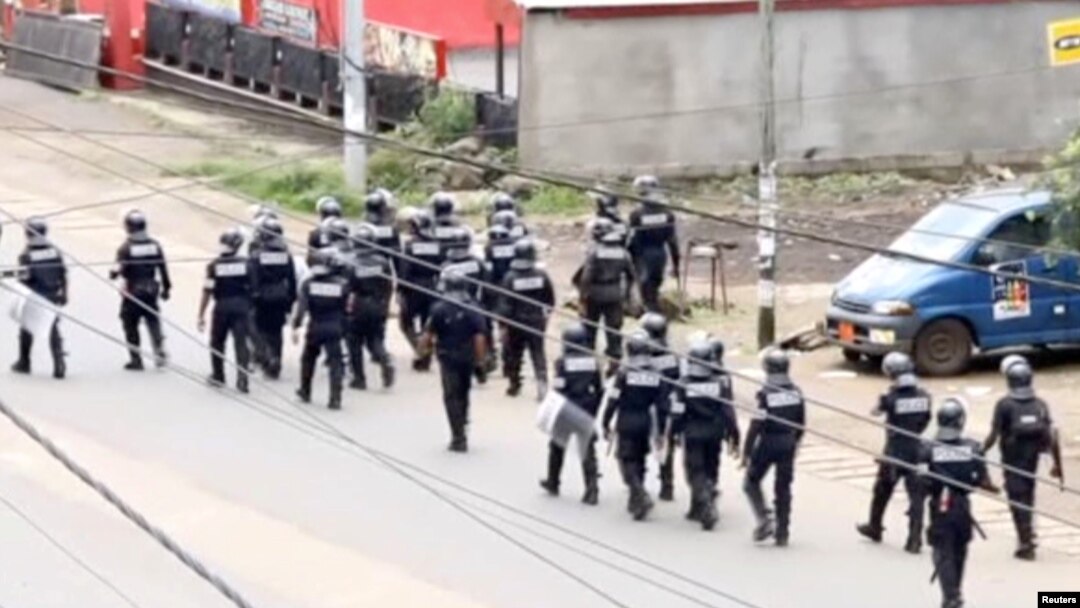 FILE - A still image taken from video shows riot police walk along a street in the English-speaking city of Buea, Cameroon, Oct. 1, 2017.
