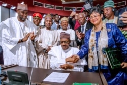 FILE - Nigerian President Muhammadu Buhari signs an agreement during African Union summit in Niamey, July 7, 2019.