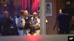 An injured hostage is carried to an ambulance after shots were fired during the siege in the central business district of Sydney, Australia. (AP Photo/Rob Griffith)