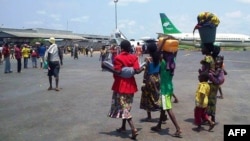 Women and children walk with on the tarmac of Bangui's international airport, Aug. 28, 2013. 